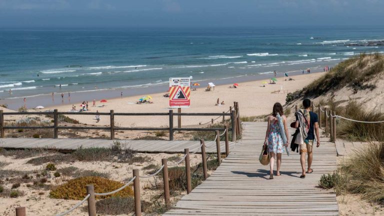 Vista da Praia do Malhão com pessoas a caminhar para a praia